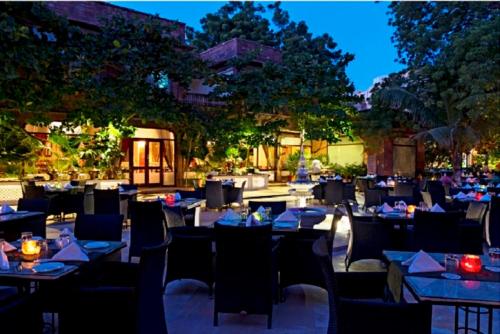 a restaurant with blue tables and chairs and trees at Ranbanka Palace in Jodhpur