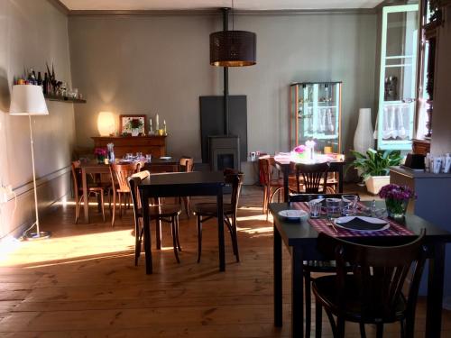 ein Esszimmer mit Tischen und Stühlen in einem Raum in der Unterkunft La Maison de famille in Boën