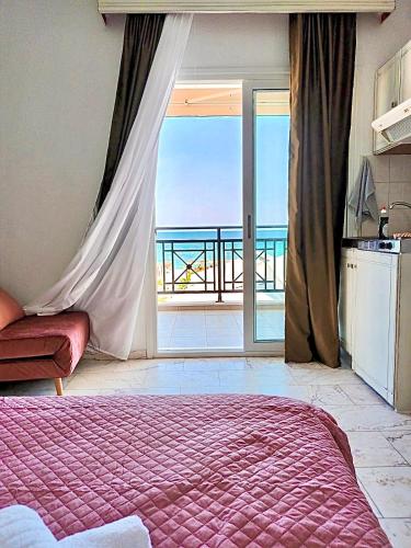 a bedroom with a bed and a view of the ocean at Waves Studios in Chrysi Ammoudia