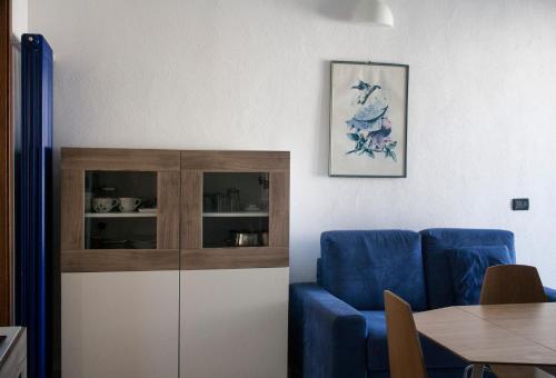 uma sala de estar com um sofá azul e um armário em Via Colombo em Marina di Massa