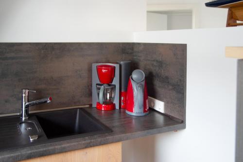 a kitchen counter with a sink and a red blender at SüdWind, Haus Portscher in Norderney