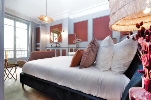 une chambre avec un grand lit avec des oreillers dans l'établissement The Lord Byron Suite, à Paris