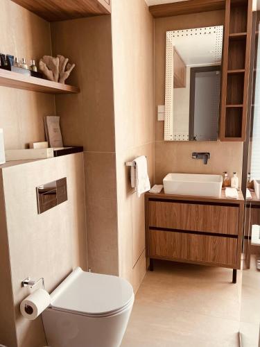 a bathroom with a toilet and a sink and a mirror at AHT22 premium beach residence in Pärnu