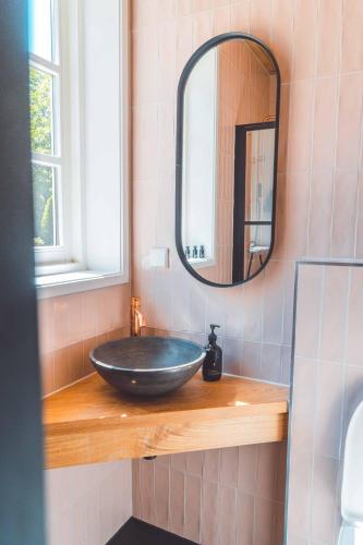 a bathroom with a black sink and a mirror at Buitenliefde, romantisch verblijf voor 2 personen in Heiloo