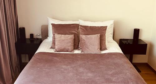 łóżko z 2 poduszkami i 2 szafkami nocnymi w obiekcie AHT22 premium beach residence w Parnawie