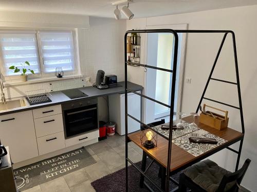 a kitchen with a counter and a table in a room at La cave du Pi'Style in Ingwiller