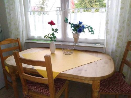 una mesa de madera con un jarrón de flores en una ventana en Ferienwohnung Finn im Haus Maarten en Cuxhaven