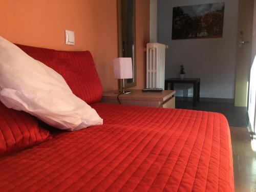 a bedroom with a red bed with a red comforter at Hotel Roc de St Miquel & Apartment in Soldeu