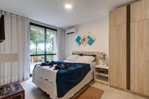um quarto com uma cama e uma grande janela em Wai Wai Cumbuco Apartamento Térreo em Cumbuco