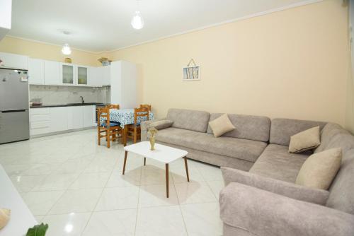 a living room with a couch and a table at DANTE APARTAMENT in Vlorë
