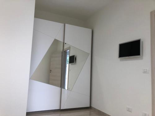a mirror in a room with a tv on a wall at Salento Appartamento Sole in Marina di Mancaversa