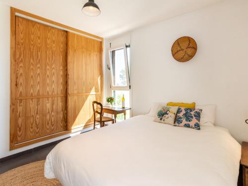 a bedroom with a white bed and a wooden cabinet at Casa Ishtar in Nigüelas
