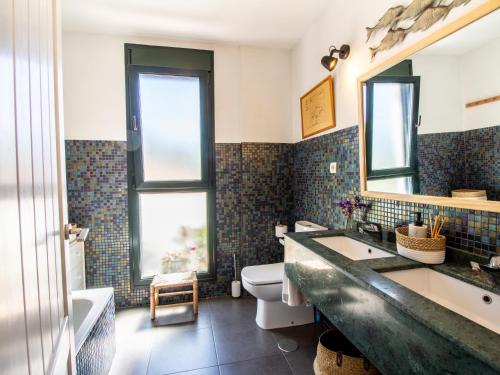 a bathroom with a sink and a toilet and a mirror at Casa Ishtar in Nigüelas