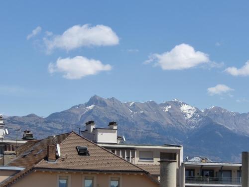 uma vista para as montanhas nevadas a partir dos telhados dos edifícios em Gap, appartement calme au coeur de la vielle ville em Gap
