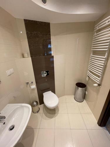 een witte badkamer met een toilet en een wastafel bij ceynowy1 in Sopot