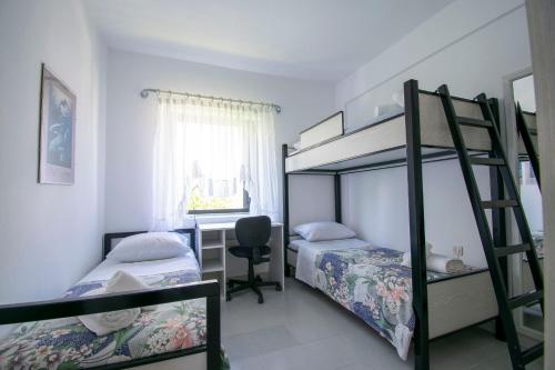 a bedroom with two bunk beds and a desk at Esperida Apartment by RentalsPro - Fourka Beach Halkidiki in Skala Fourkas