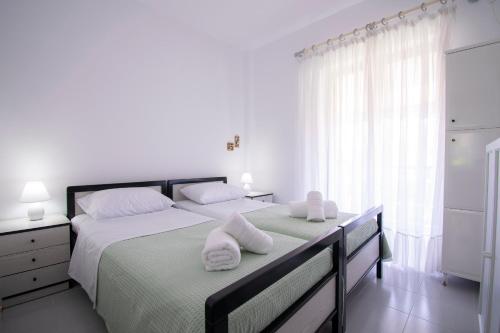 a bedroom with a large bed with towels on it at Esperida Apartment by RentalsPro - Fourka Beach Halkidiki in Skala Fourkas