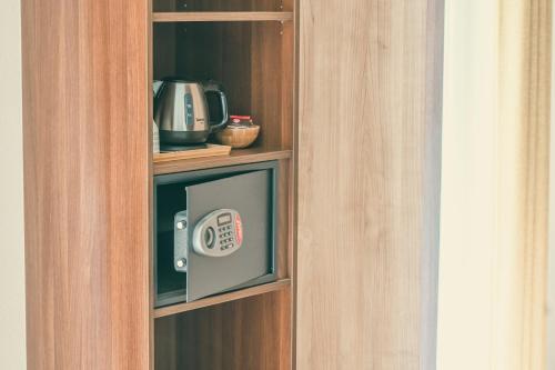 een boekenplank met een magnetron in een kamer bij Hôtel Casa 49 in Remich