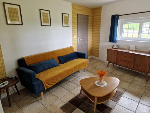 a living room with a couch and a table at L'hacienda de Soubran, Le Gîte à Grand-mère, classé 4 étoiles in Soubran
