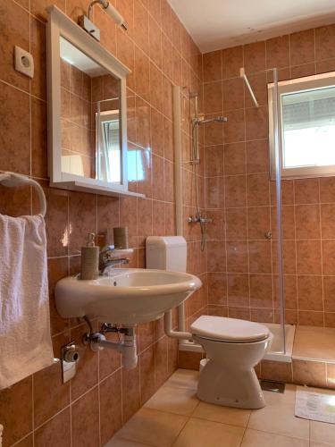 La salle de bains est pourvue d'un lavabo, de toilettes et d'une douche. dans l'établissement Apartment Sunset, à Zadar