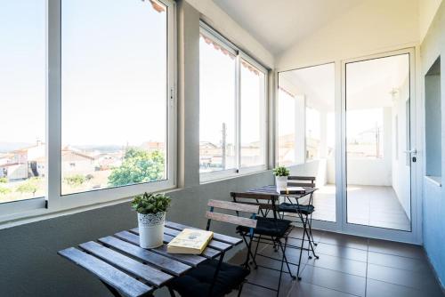 a room with a table and chairs and windows at What Else Guest House - Fatima in Fátima