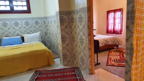 a bedroom with two beds and a door to a room at Dar Relax Hostel, Gorges de Todra in Tinerhir