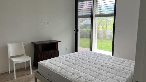 een slaapkamer met een bed, een stoel en een raam bij Apartment Lake Garda in Garda