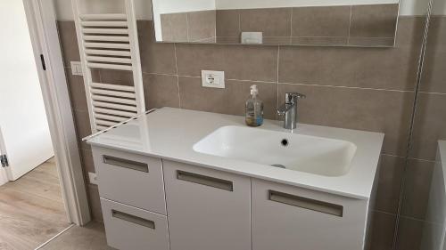 een badkamer met een witte wastafel en een spiegel bij Apartment Lake Garda in Garda