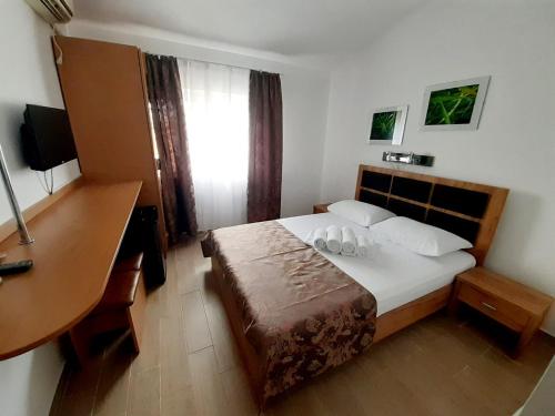 a hotel room with a bed and a desk and a desk at Vila karla in Eforie Nord