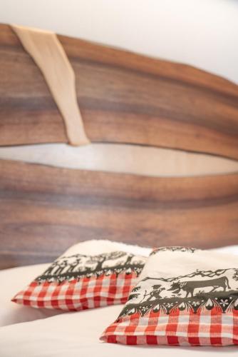 two pillows on a bed with a wooden head board at Hotel Wasserfall in Jaun