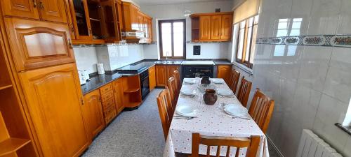 una cocina con armarios de madera y una mesa con platos. en Apartamento Rural Playa Foz - VISTAS AL MAR, en Foz