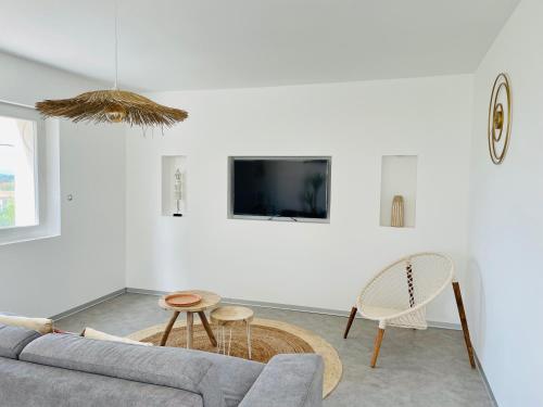 ein Wohnzimmer mit einem Sofa, einem Tisch und einem TV in der Unterkunft La tour de Lézan in Lèzan