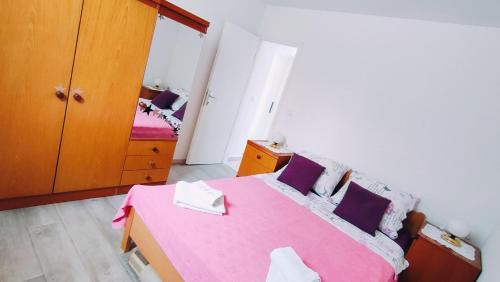 a bedroom with a pink bed with purple pillows at Apartment Bitinada in Rovinj