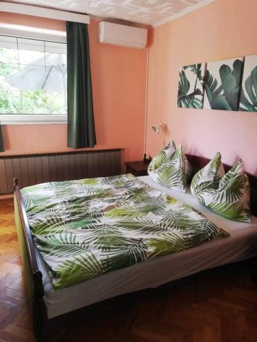 a bedroom with a bed with pillows and a window at Oázis Apartman in Szántód