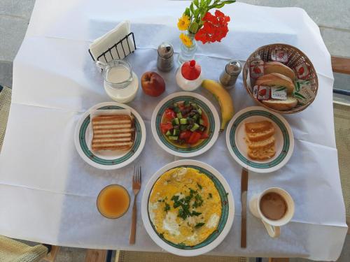 a table with plates of breakfast food on it at Niros Beachfront Aparthotel in Kokkíni Khánion