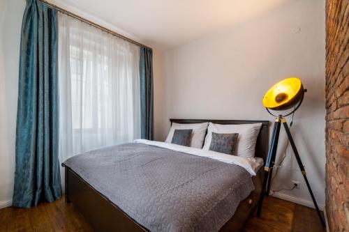 a bedroom with a bed with a yellow lamp and a window at Boutique hotel Soukeníkův dům in Kutná Hora