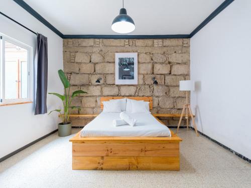 um quarto com uma cama e uma parede de tijolos em Cathedral Apartment em Las Palmas de Gran Canaria
