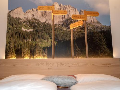a bedroom with a mountain mural on the wall at Hotel Wasserfall in Jaun