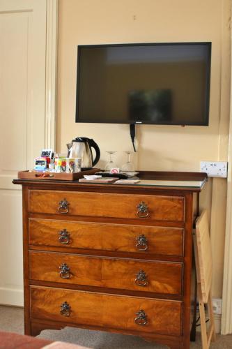 a dresser with a flat screen tv on top of it at Wortley Cottage Guest House in Wortley