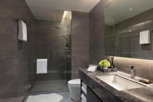 a bathroom with a sink and a shower at Ascott Embassy Sathorn Bangkok in Bangkok