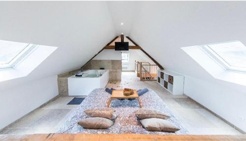 Habitación con almohadas y mesa en el ático en L'évasion-SPA-Hammam-Sauna Illimité - 2 à 4 pers en Saint-Cyr-sur-Loire