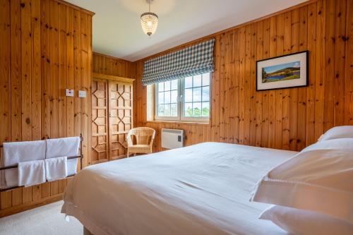 a bedroom with a large bed and a window at Braemoray in Evanton