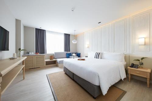 sypialnia z dużym białym łóżkiem i kanapą w obiekcie Health Land Resort & Spa w Pattaya South