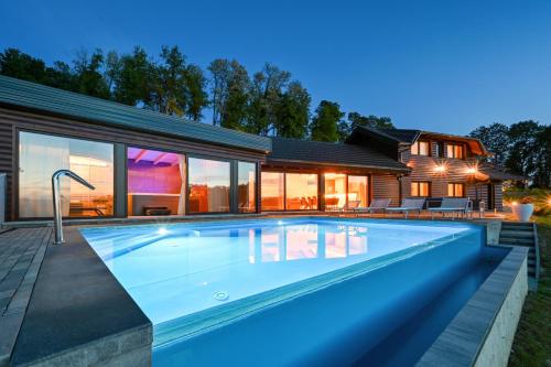 a swimming pool in front of a house at Ville Pačetina in Lepajci