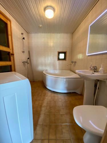 a bathroom with a tub and a sink and a toilet at Himos Mökki in Jämsä