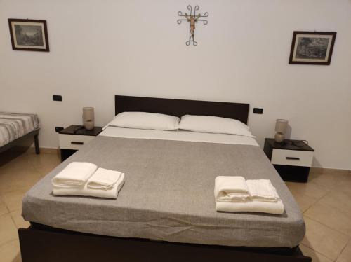 a bedroom with a large bed with towels on it at IL CONTE DI MARRAONE in Agnone