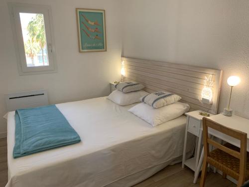 - une chambre avec un lit avec deux oreillers et un bureau dans l'établissement Le nid de la Mouette, à Argelès-sur-Mer