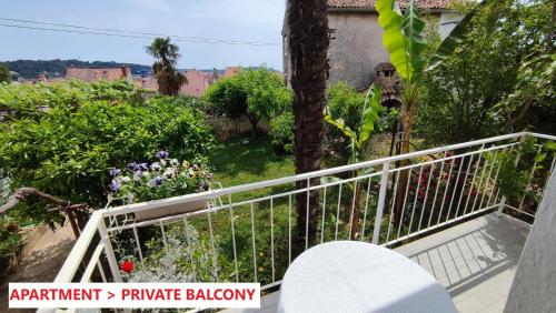 a balcony of a house with a tree and flowers at Apartment Bitinada in Rovinj