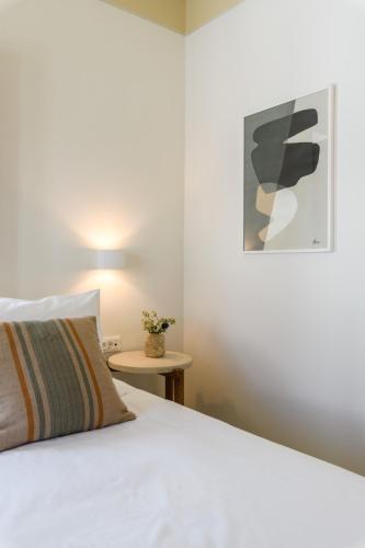 a bedroom with a white bed and a table at Camarades Mykonos in Ano Mera