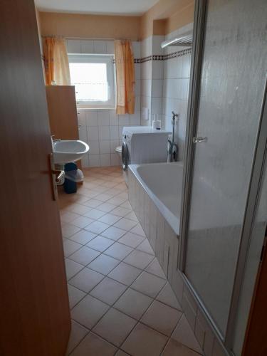 une salle de bains avec baignoire et lavabo dans l'établissement Ferienwohnung im Seidlerhof mit Terrasse, à Röhrnbach